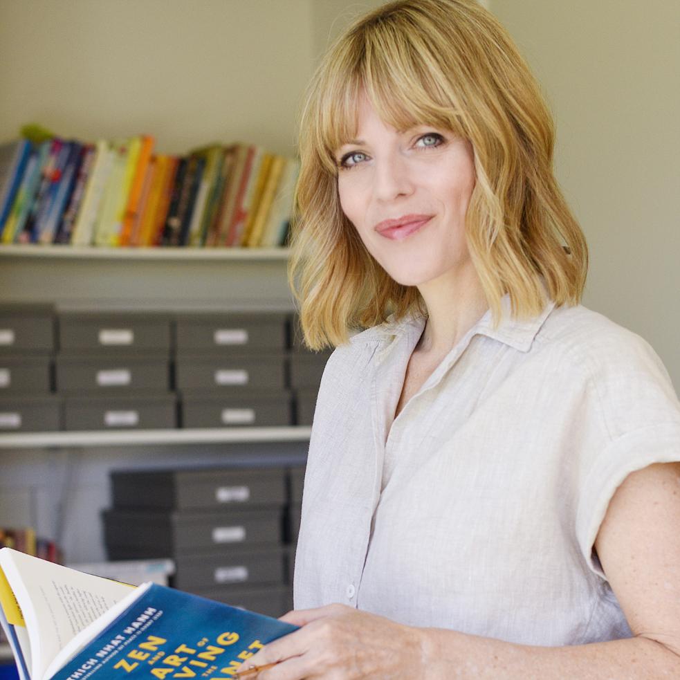 Amy in her office with Thich Nhat Hanh's book Zen and the art of saving the planet